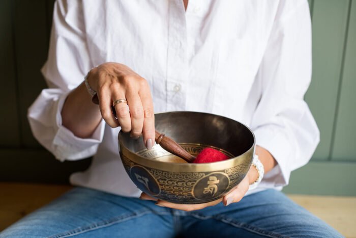 Close-up van een hand die een klankschaal bespeelt tijdens een branding sessie in Breda.
