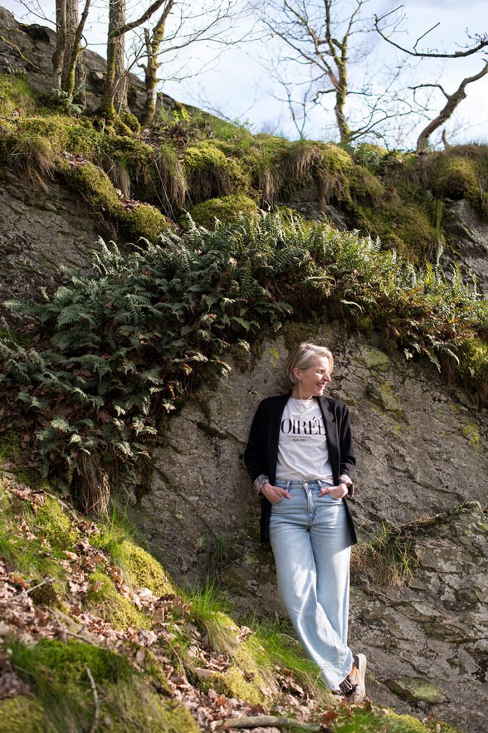 Outdoor personal branding shoot in de Ardennen: fotografe lachend bij een rotswand.