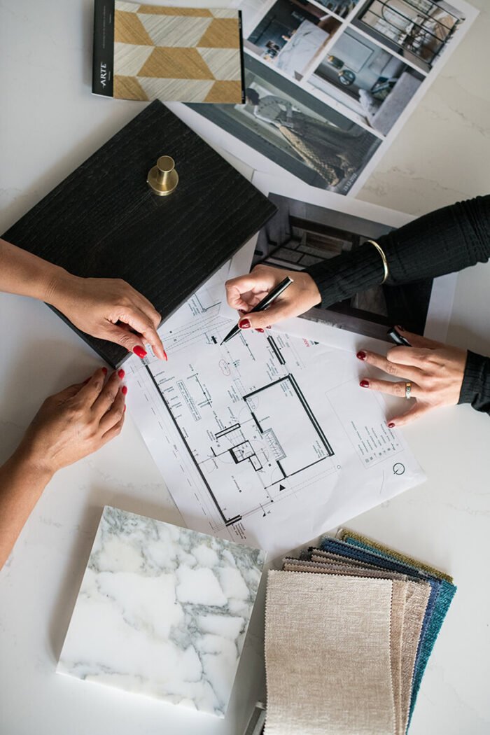 Close-up van handen van een interieurarchitect met materiaalstalen tijdens klantadvies in Brabant.