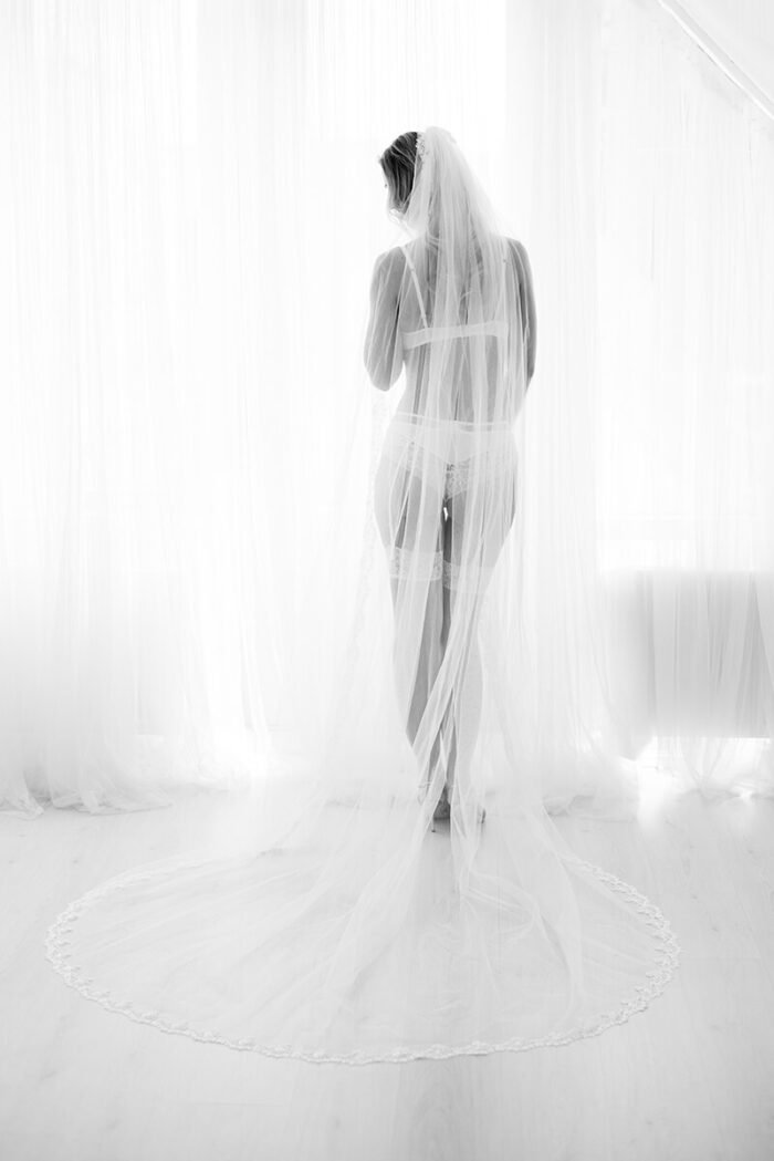 Boudoir fotografie Breda van bruid in sluier als zacht silhouet in zwart wit