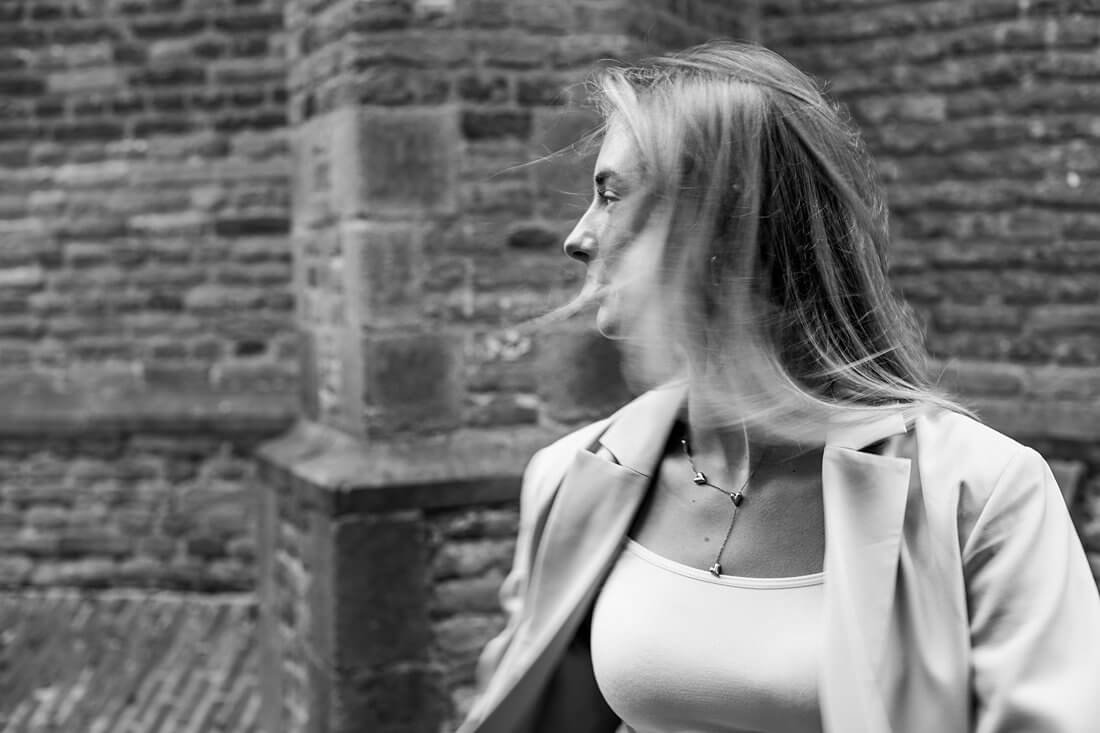 Onderneemster Sarah met handen in de zakken van haar grijze pak in Nijmegen.